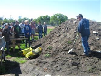 students working with pile of dirt